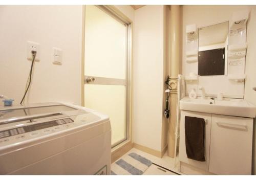 uma cozinha branca com um lavatório e um fogão em Woody Sanheim - Vacation STAY 12558 em Tóquio