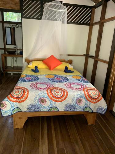 a bed with a colorful comforter in a room at Pequeño Paraiso 1 in Punta Uva