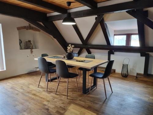 a dining room with a table and chairs at Galerie Vila Lucia 5 -Loft apartmán in Plzeň
