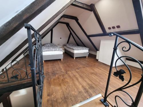 an attic room with two beds and a staircase at Galerie Vila Lucia 5 -Loft apartmán in Plzeň