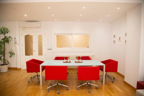 a dining room with a white table and red chairs at SAN MARCOS in Almansa