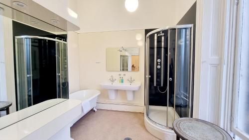 a white bathroom with a shower and a sink at The Guards Hotel in Edinburgh