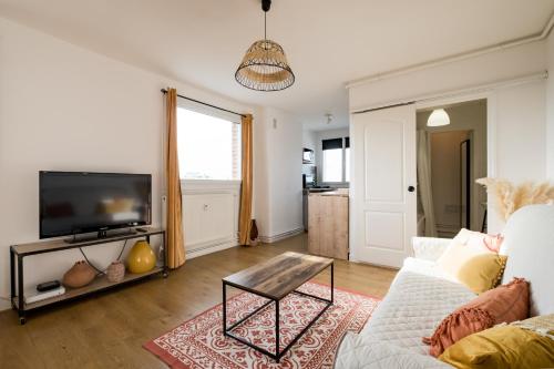 un salon avec un canapé et une télévision dans l'établissement Studio d'exception en hyper centre, Sweetloc Immo, à Lille