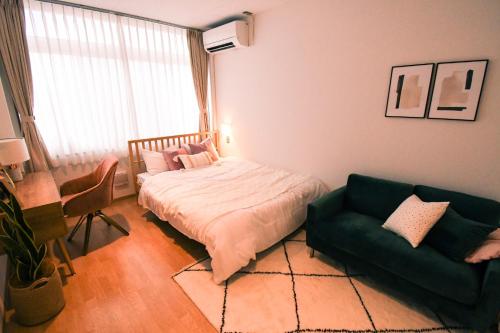 a bedroom with a bed and a couch at Manabiamu 4F - Vacation STAY 53983v in Maizuru