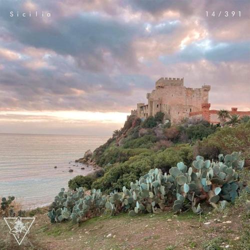 a castle on top of a hill next to the ocean at Alessi Suites & Studio in Mazzarino