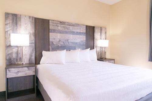a large white bed in a hotel room with two lamps at The Stone Castle Hotel & Conference Center in Branson