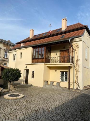 a large white building on a cobblestone street at Galerie Vila Lucia 5 -Loft apartmán in Plzeň