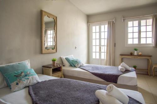 1 dormitorio con 2 camas y espejo en Golden Sun Boutique, en Malia
