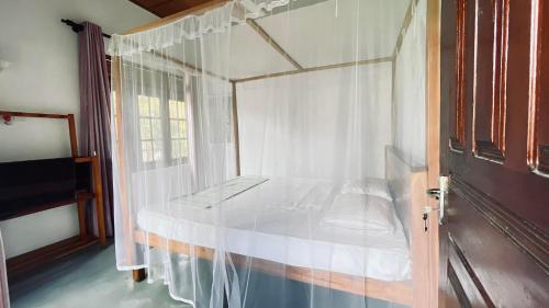 a bedroom with a canopy bed with a window at Kiara Sands in Mirissa