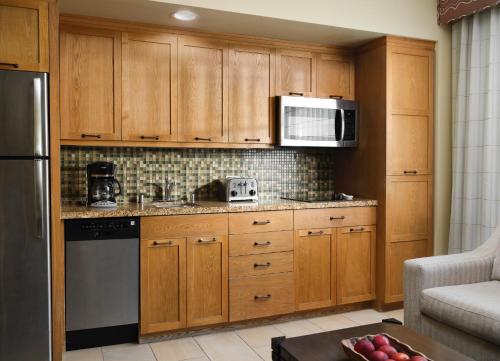 a kitchen with wooden cabinets and a microwave at Hyatt Vacation Club at the Welk, San Diego in Escondido