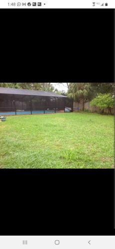 a large green field of grass with a building in the background at A Touch of Madagascar in Fort Walton Beach with HEATING POOL in Fort Walton Beach