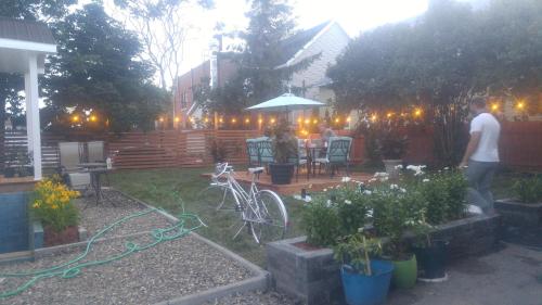 a man standing in a garden with a bike at Auberge Jeunesse à Loulou in Lévis