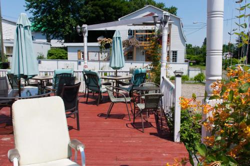 a patio with tables and chairs and umbrellas at Auberge Jeunesse à Loulou in Lévis