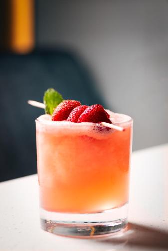 a drink with strawberries on top of a table at Novotel Arica in Arica