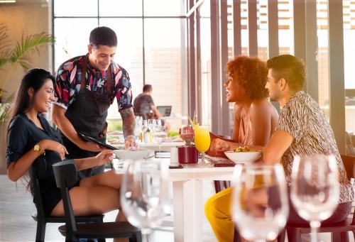 a group of people sitting at a table in a restaurant at Novotel Arica in Arica