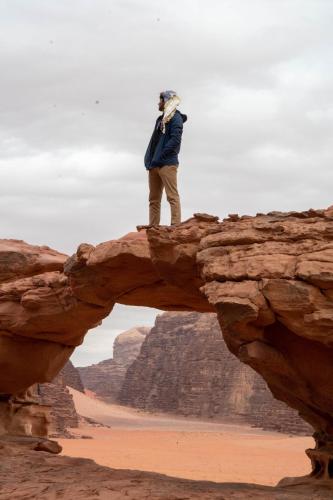 a man standing on a bridge in the desert at Wadi Rum Nights in Wadi Rum
