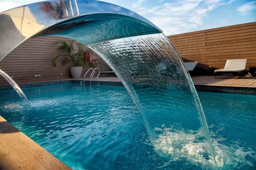 a swimming pool with a water fountain in the middle at Novotel Arica in Arica