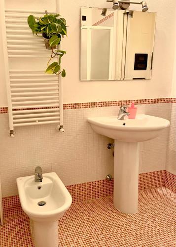 a bathroom with a sink and a toilet and a mirror at WINE & LAKE IN FRANCIACORTA in Passirano