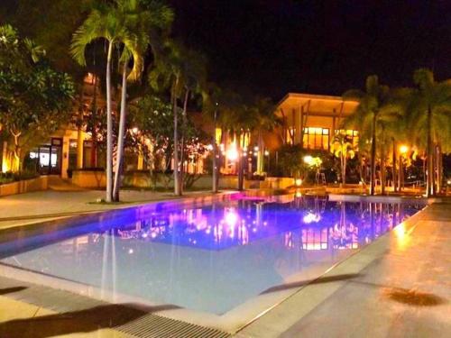a swimming pool at night with blue lights at Beach condos at Pico de Loro Cove - Wi-Fi & Netflix, 42-50''TVs with Cignal cable, Uratex beds & pillows, equipped kitchen, balcony, parking - guest registration fee is not included in Nasugbu
