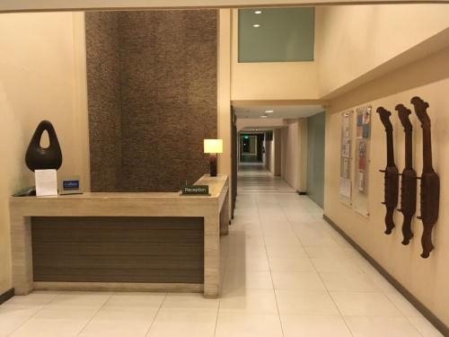 a hallway with a reception desk in a building at Beach condos at Pico de Loro Cove - Wi-Fi & Netflix, 42-50''TVs with Cignal cable, Uratex beds & pillows, equipped kitchen, balcony, parking - guest registration fee is not included in Nasugbu