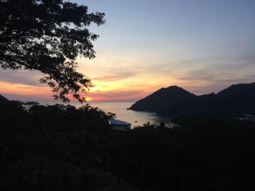 a sunset over a body of water with a mountain at Beach condos at Pico de Loro Cove - Wi-Fi & Netflix, 42-50''TVs with Cignal cable, Uratex beds & pillows, equipped kitchen, balcony, parking - guest registration fee is not included in Nasugbu