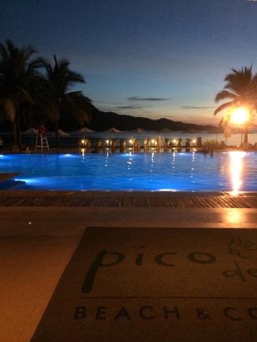 a swimming pool at night with a sign in front of it at Beach condos at Pico de Loro Cove - Wi-Fi & Netflix, 42-50''TVs with Cignal cable, Uratex beds & pillows, equipped kitchen, balcony, parking - guest registration fee is not included in Nasugbu