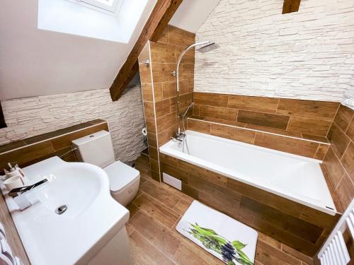 a bathroom with a white toilet and a bath tub at Apartmánový dům 13 Mezonet 1 in Seč