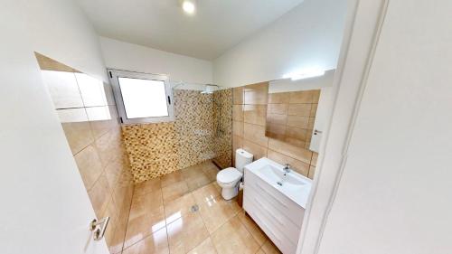 een badkamer met toilet, wastafel en raam bij Villa Cassolino in Ribeira Brava