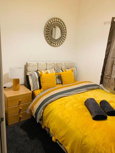 sypialnia z łóżkiem z żółtymi poduszkami i lustrem w obiekcie City Blessed Aptm 3 with Free Parking w mieście North Shields