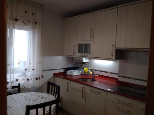 a kitchen with a sink and a table and a window at Apartamento Portugalete in Portugalete