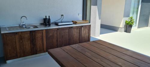 a kitchen with wooden cabinets and a sink at Villa Sky - Heating Pool in Kastel Novi
