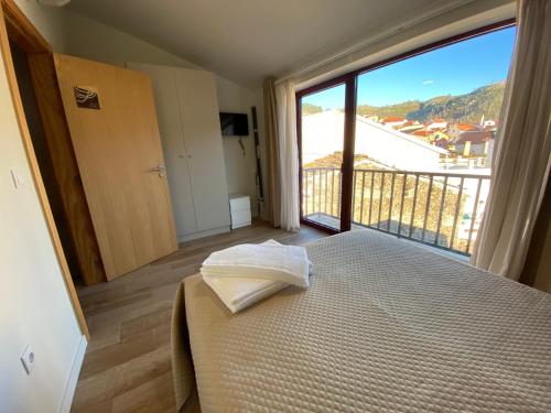 a bedroom with a bed and a large window at Casa dos Conchos 2 in Sabugueiro