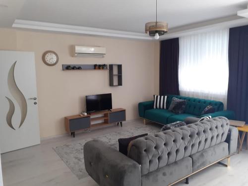 a living room with a couch and a television at Canans Home in Demre