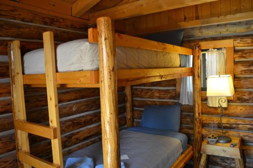 a bedroom with two bunk beds in a log cabin at Escalante Outfitters in Escalante