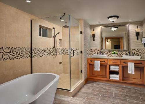 a bathroom with a tub and a glass shower at Hyatt Vacation Club at The Lodges at Timber Ridge in Branson