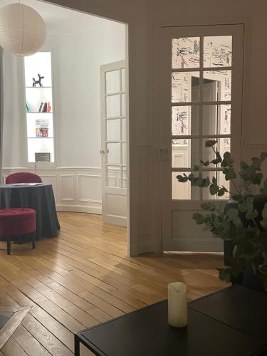 a living room with a table and a glass door at Les Berceaux de la Cathedrale in Reims