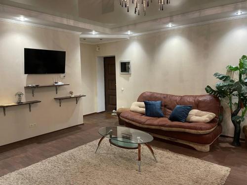 sala de estar con sofá de cuero marrón y TV en Кривой Рог, 95 квартал, Гагарина 3, Люкс апартаменты en Krivói Rog