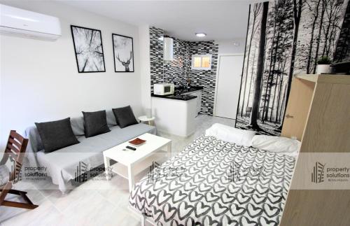 sala de estar con sofá y mesa en 243 Águila apartamentos - Estudio vista al mar - Piscina y Playa, en Benalmádena