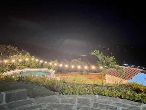 a park with a pool at night with lights at Cabañas San Miguel Arcángel in San Gil