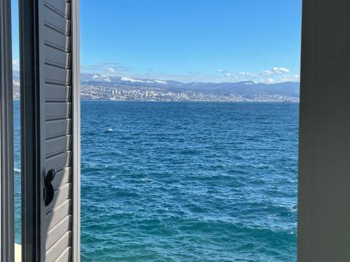 a view of the ocean from a window at First row to the sea - Nautilus Deluxe Apartment in Opatija