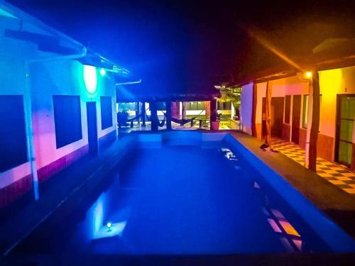 a swimming pool in the middle of a house at night at El Curichal Hostel in Rurrenabaque