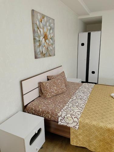 a small bedroom with a bed and a painting on the wall at Hotel and Entertaiment Complex Vlada in Cherkasy