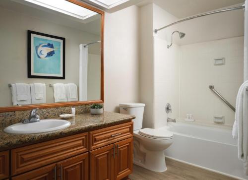 a bathroom with a sink and a toilet and a tub at Desert Oasis by Vacation Club Rentals in Cathedral City