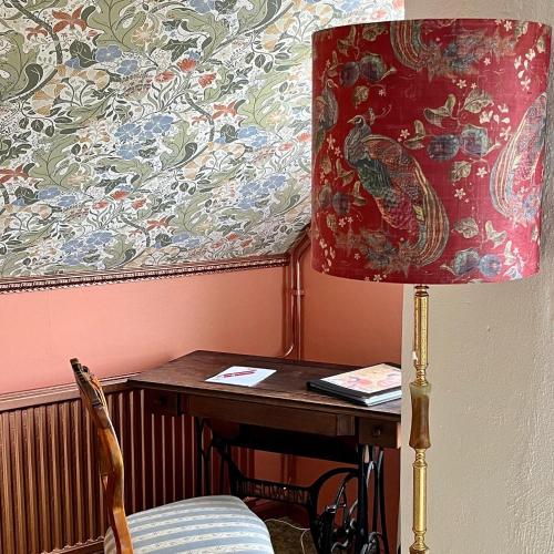 a table with a lamp and a table with a chair at Sydkustens at Pillehill in Skivarp