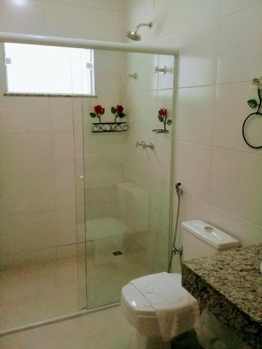 a bathroom with a glass shower with a toilet at Hotel Pousada Riacho da Areia in Águas de Lindóia