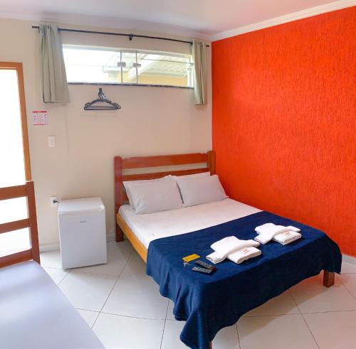 a bedroom with a bed with two towels on it at Poupahotel Unidade Bairro in Taubaté