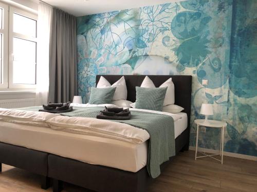 a bedroom with a large bed with blue and green wallpaper at Zur alten Fabrik in Steinach