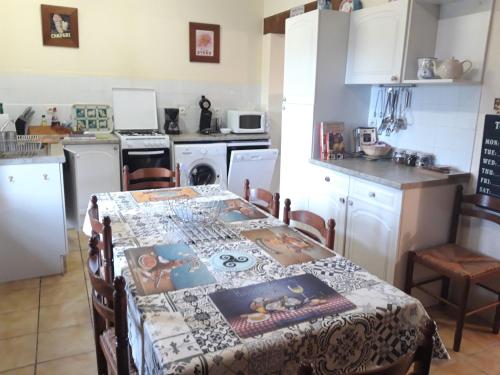a kitchen with a table with a table cloth on it at Gîte La Grange in Langoëlan