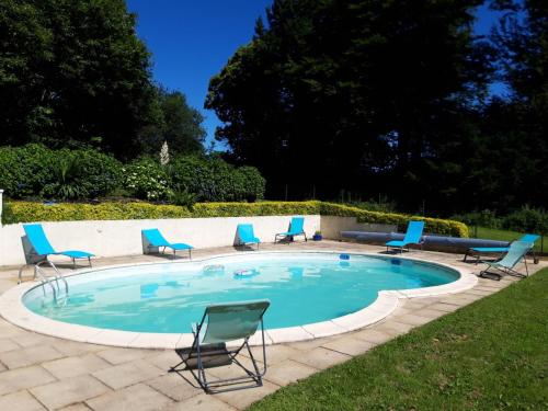 einen Pool mit Liegestühlen und einem Tisch in der Unterkunft Gîte La Grange in Langoëlan