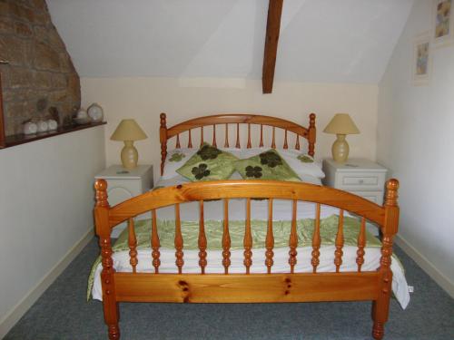 a bedroom with a wooden bed with two night stands at Gîte La Grange in Langoëlan